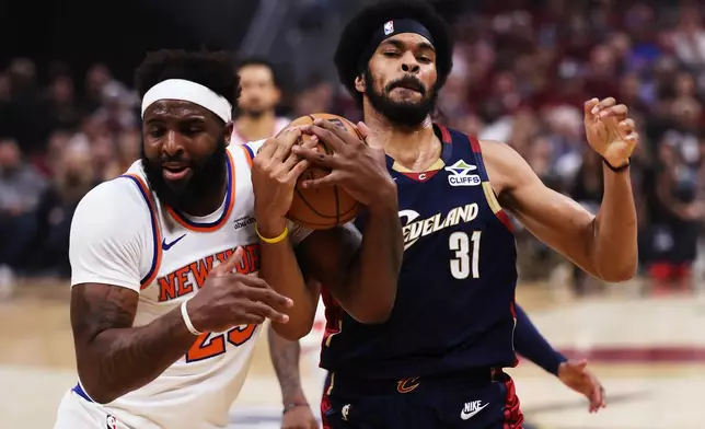 New York Knicks center Mitchell Robinson (23) and Cleveland Cavaliers center Jarrett Allen (31) battle for the ball during the first half of Game 4 in the Eastern Conference finals NBA basketball playoffs series in Cleveland, Monday, May 25, 2026. (AP Photo/Tim Phillis)