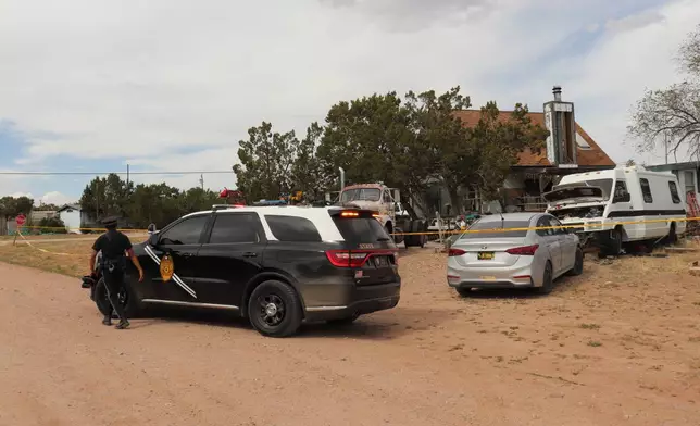 New Mexico State Police respond to home in Mountainair, N.M., where authorities say several people died Wednesday, May 20, 2026, and more than a dozen first responders were exposed to an unknown substance and later treated at a hospital. (AP Photo/Savannah Peters)