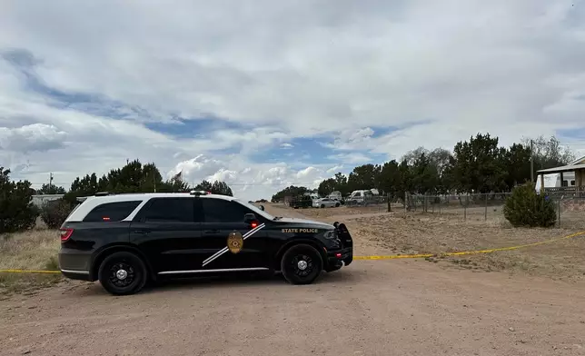 A New Mexico State Police vehicle blocks off a neighborhood in Mountainair, N.M., where authorities say several people died Wednesday, May 20, 2026, and more than a dozen first responders were exposed to an unknown substance and later treated at a hospital. (AP Photo/Savannah Peters)
