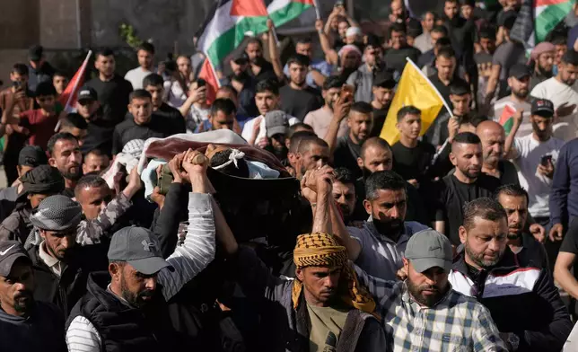 Mourners carry the body of Yousef Ka'abnah, 16, who was killed by Israeli army fire earlier today, during his funeral in West Bank village of al-Lubban al-Sharqiya, Wednesday, May 13, 2026. (AP Photo/Majdi Mohammed)