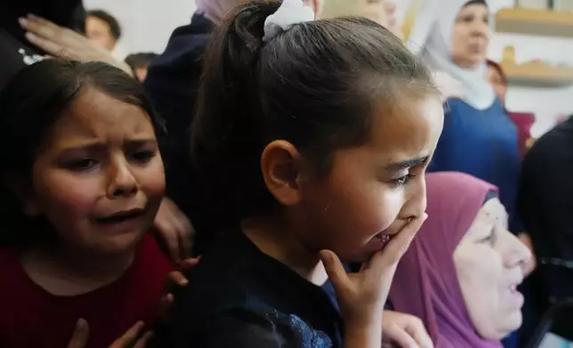 Children cry while they take the last look at the body of Palestinian Zakaria Qatousa, during his funeral in the West Bank town of Deir Qaddis Wednesday, May 13, 2026. (AP Photo/Mahmoud Illean)