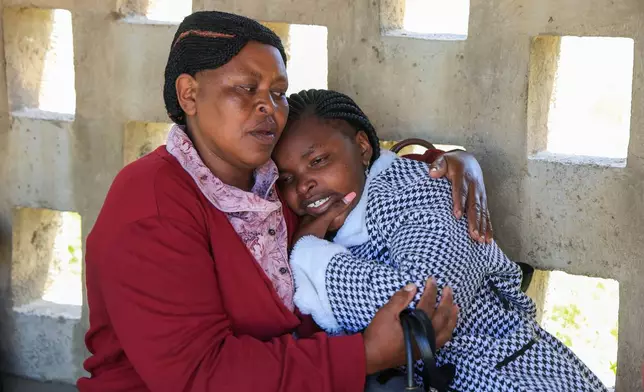 A parent of a victim of the fire at the Utumishi Girls Academy is consoled ahead of body identification and DNA testing at Naivasha Funeral Home in Naivasha Town, Rift Valley region, Kenya, Friday, May 29, 2026. (AP Photo/Andrew Kasuku)