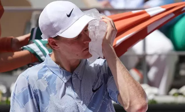Jannik Sinner of Italy cools himself with the ice during the second round men's singles tennis match against Juan Manuel Cerundolo of Argentina at the French Open tennis tournament in Paris, Thursday, May 28, 2026. (AP Photo/Thibault Camus)