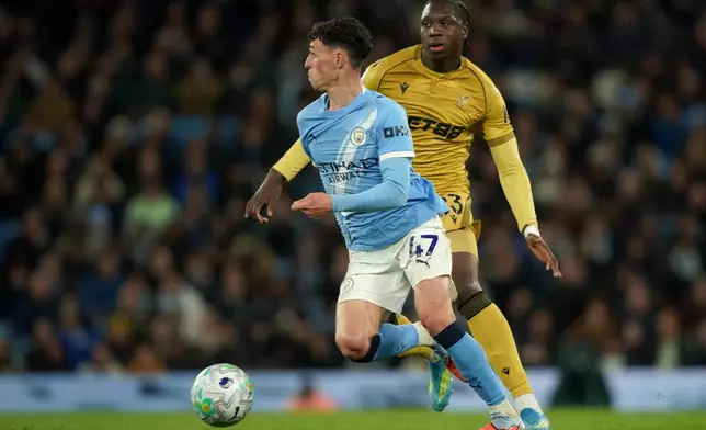 Manchester City's Phil Foden, front, and Crystal Palace's Jaydee Canvot challenge for the ball during the English Premier League soccer match between Manchester City and Crystal Palace in Manchester, England, Wednesday, May 13, 2026. (AP Photo/Ian Hodgson)
