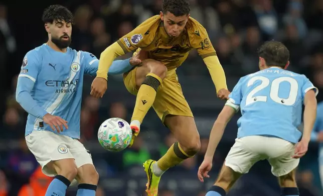 Crystal Palace's Brennan Johnson, center, challenges for the ball with Manchester City's Josko Gvardiol, left, and Manchester City's Bernardo Silva during the English Premier League soccer match between Manchester City and Crystal Palace in Manchester, England, Wednesday, May 13, 2026. (AP Photo/Ian Hodgson)