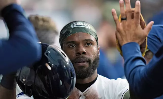 Tampa Bay Rays' Cedric Mullins celebrates in the dugout after scoring on a fielder's choice by Taylor Walls off Miami Marlins pitcher Janson Junk during the second inning of a baseball game Friday, May 15, 2026, in St. Petersburg, Fla. (AP Photo/Chris O'Meara)
