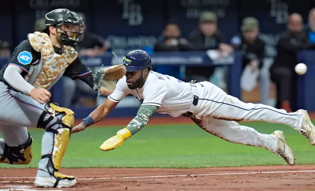 Tampa Bay Rays' Cedric Mullins, right, scores ahead of the throw to Miami Marlins catcher Joe Mack on a fielder's choice by Taylor Walls during the second inning of a baseball game Friday, May 15, 2026, in St. Petersburg, Fla. (AP Photo/Chris O'Meara)