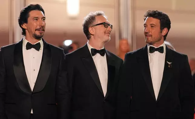 Adam Driver, left, director James Gray and Miles Teller pose for photographers upon arrival at the premiere of the film 'Paper Tiger' at the 79th international film festival, Cannes, southern France, Saturday, May 16, 2026. (AP Photo/John Locher)