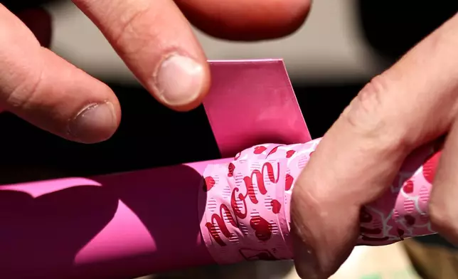 Mothers day-themed bat tape is applied to a Chicago White Sox baseball bat before a game against against the Seattle Mariners at Rate Field on Sunday, May 10, 2026, in Chicago, Ill. (AP Photo/Geoff Stellfox)