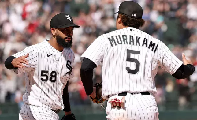 Chicago White Sox pitcher Seranthony Domínguez (58) celebrates after the team's win against the Seattle Mariners with first baseman Munetaka Murakami (5), Sunday, May 10, 2026, in Chicago. (AP Photo/Geoff Stellfox)