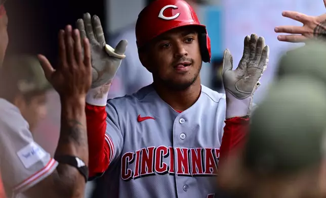 Cincinnati Reds' Dane Myers is congratulated in the dugout after hitting a solo home run off Cleveland Guardians starting pitcher Joey Cantillo during the third inning of a baseball game, Saturday, May 16, 2026, in Cleveland. (AP Photo/David Dermer)
