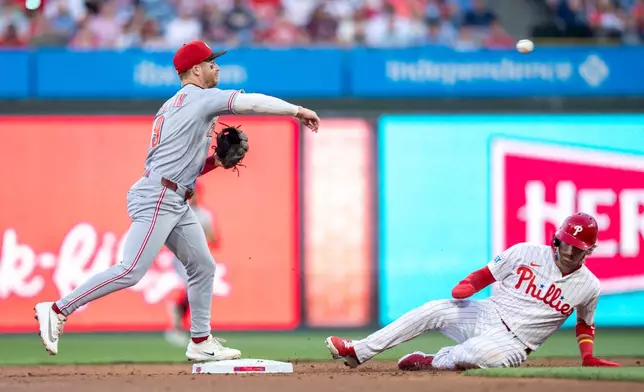 Cincinnati Reds second baseman Matt McLain, left, turns the double play as he gets a force out against Philadelphia Phillies' Bryson Stott, right, during the second inning of a baseball game, Tuesday, May 19, 2026, in Philadelphia. (AP Photo/Chris Szagola)