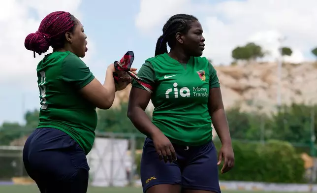 Amelie Nguedia from Cameroon, left, gives the captain's armband after being substituted to Maria Chaffi during a semifinal soccer match against Fostiras Kaisarianis for the Kypseli Mundial in Athens, Greece, on Sunday, May 24, 2026. (AP Photo/Thanassis Stavrakis)