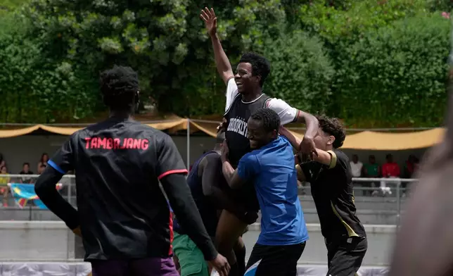 A migrant from Mali celebrates with teammates after scoring a goal during a semifinal soccer match against Congo for the Kypseli Mundial in Athens, Greece, on Sunday, May 24, 2026. (AP Photo/Thanassis Stavrakis)