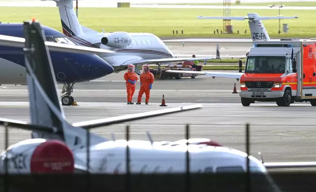 Medical personnel in hazmat suits wait for patients, evacuated from the MV Hondius cruise ship with suspected hantavirus infection, at Schiphol airport, Amsterdam, Netherlands, Wednesday, May 6, 2026. (AP Photo/Peter Dejong)