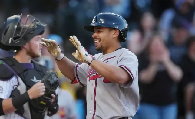 Atlanta Braves' Drake Baldwin, right, celebrates as he crosses home plate after hitting a two-run home run off Colorado Rockies starting pitcher Brennan Bernardino in the first inning of a baseball game Saturday, May 2, 2026, in Denver. (AP Photo/David Zalubowski)