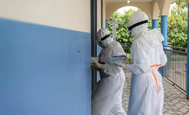 Health workers take meals to Ebola patients at the treatment center in Rwampara, Congo, Friday, May 29, 2026. (AP Photo/Moses Sawasawa)