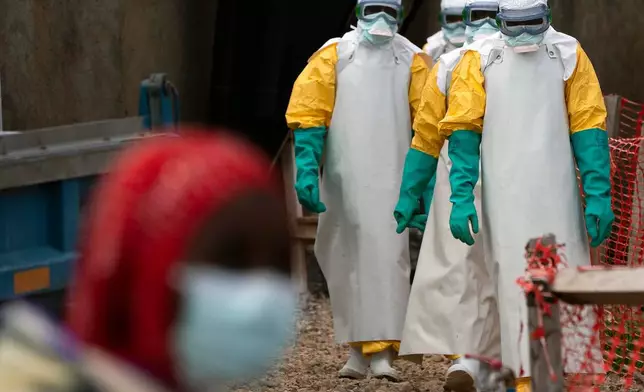 FILE - Health workers dressed in protective gear begin their shift at an Ebola treatment center in Beni, Congo, July 16, 2019. (AP Photo/Jerome Delay, File)
