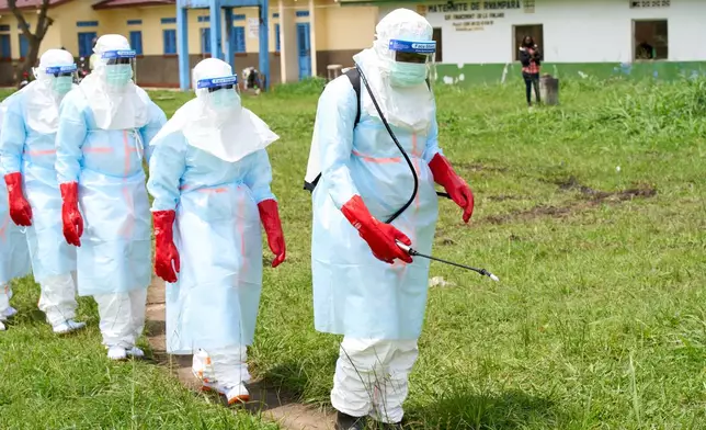 Health workers arrive at a treatment center for disinfection exercises in Rwampara, Congo, Thursday, May 21, 2026. (AP Photo/Dirole Lotsima Dieudonne)