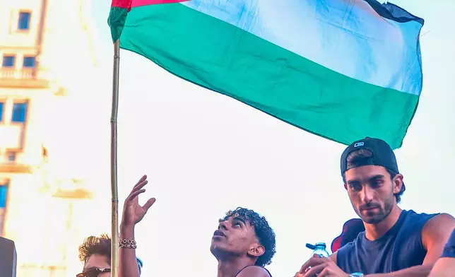FC Barcelona player Lamine Yamal holds a Palestinian flag as he celebrates with his team atop a bus after winning the Spanish La Liga title in Barcelona, Spain, Monday, May 11, 2026. (AP Photo)