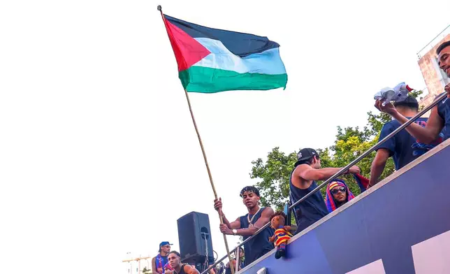 FC Barcelona player Lamine Yamal holds a Palestinian flag as he celebrates with his team atop a bus after winning the Spanish La Liga title in Barcelona, Spain, Monday, May 11, 2026. (AP Photo)
