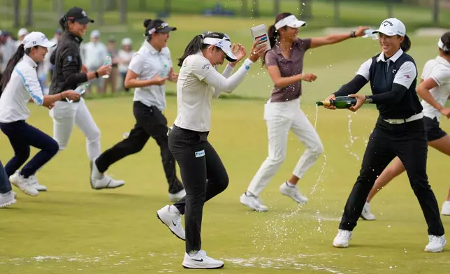 Jeeno Thitikul, of Thailand, center, is sprayed with champagne after winning the Mizuho Americas Open golf tournament, Sunday, May 10, 2026, in West Caldwell, N.J. (AP Photo/Seth Wenig)