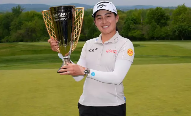 Jeeno Thitikul, of Thailand, poses for a picture with the trophy after winning the Mizuho Americas Open golf tournament, Sunday, May 10, 2026, in West Caldwell, N.J. (AP Photo/Seth Wenig)