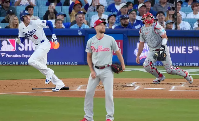 Los Angeles Dodgers' Freddie Freeman, left, heads to first for a solo home run as Philadelphia Phillies starting pitcher Zack Wheeler, center, and catcher J.T. Realmuto watch during the first inning of a baseball game Friday, May 29, 2026, in Los Angeles. (AP Photo/Mark J. Terrill)