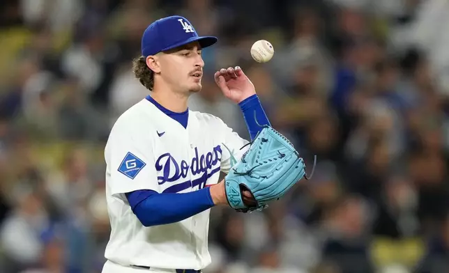 Los Angeles Dodgers pitcher Justin Wrobleski tosses a new ball in the air after giving up a solo home run to Philadelphia Phillies' Kyle Schwarber during the sixth inning of a baseball game Friday, May 29, 2026, in Los Angeles. (AP Photo/Mark J. Terrill)
