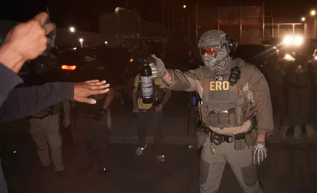 A federal immigration officer aims an OC canister at protesters outside Delaney Hall detention center Thursday, May 28, 2026, in Newark, N.J. (AP Photo/Angelina Katsanis)