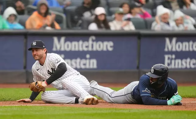 New York Yankees third baseman Ryan McMahon, left, looks up after tagging Tampa Bay Rays' Junior Caminero at third base to end the eighth inning of a baseball game, Sunday, May 24, 2026, in New York. (AP Photo/Seth Wenig)