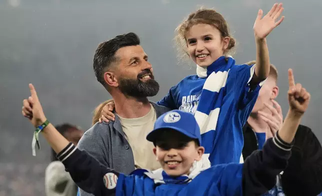 Schalke's head coach Miron Muslic celebrates with family members at the end of the German Bundesliga 2 soccer match between FC Schalke 04 and Fortuna Duesseldorf in Gelsenkirchen, Germany, Saturday, May 2, 2026. (AP Photo/Martin Meissner)