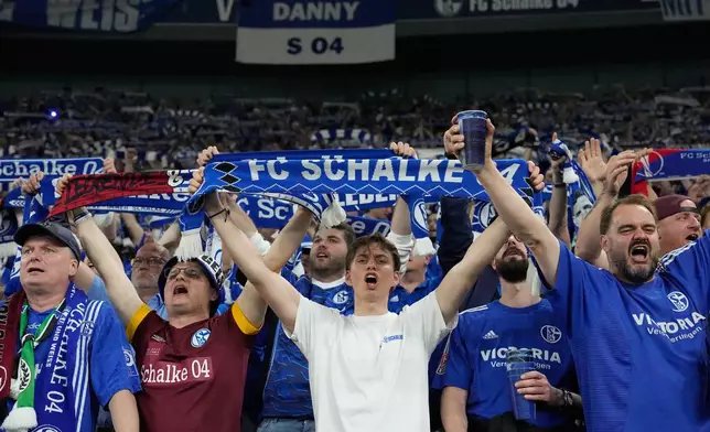 Schalke fans sing and hold up scarves prior to the German Bundesliga 2 soccer match between FC Schalke 04 and Fortuna Duesseldorf in Gelsenkirchen, Germany, Saturday, May 2, 2026. (AP Photo/Martin Meissner)