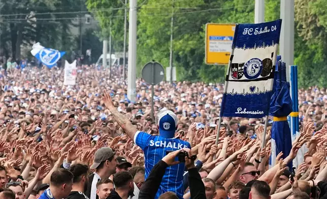 FC Schalke 04 supporters march to the stadium ahead of their 2. Bundesliga match against Fortuna Duesseldorf, where their club can secure early promotion back to the Bundesliga with a win in the evening at the Arena in Gelsenkirchen, Germany, Saturday, May 2, 2026. (AP Photo/Martin Meissner)