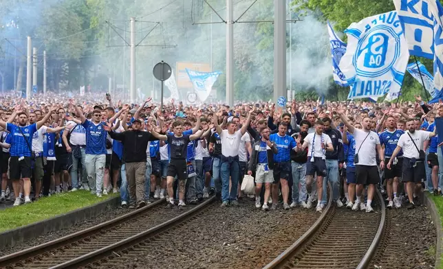 FC Schalke 04 supporters march to the stadium ahead of their 2. Bundesliga match against Fortuna Duesseldorf, where their club can secure early promotion back to the Bundesliga with a win in the evening at the Arena in Gelsenkirchen, Germany, Saturday, May 2, 2026. (AP Photo/Martin Meissner)