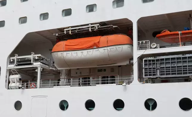 A barrier is set in front of the British cruise ship Ambition, as French authorities have ordered 1,700 passengers and crew to stay on board due to a gastrointestinal illness outbreak, in Bordeaux, southwestern France, Wednesday, May 13, 2026. (AP Photo/Caroline Blumberg)