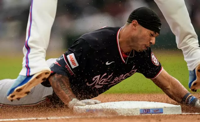 Washington Nationals' Daylen Lile slides into third base after hitting a triple in the second inning of a baseball game against the Atlanta Braves, Saturday, May 23, 2026, in Atlanta. (AP Photo/Mike Stewart)