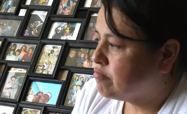 Adriana Garzon, mother of Brayan Rayo Garzon who died by suicide while in ICE custody in April 2025, sits in front of a collection of family photos in St. Louis, Friday, May 1, 2026. (AP Photo/Nick Ingram)