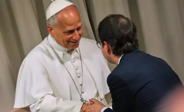 Pope Leo XIV, left, greets Anthropic co-founder Christopher Olah during the presentation of the Pope's first encyclical, "Magnifica humanitas: On Safeguarding the Human Person in the Time of Artificial Intelligence," at the Vatican, Monday, May 25, 2026. (AP Photo/Alessandra Tarantino)