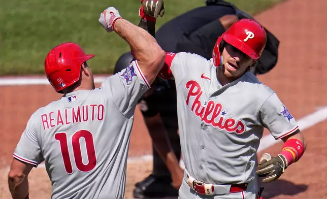 Philadelphia Phillies' Bryson Stott, right, celebrates with J.T. Realmuto (10) as he heads to the dugout after hitting a solo home run off Pittsburgh Pirates pitcher Dennis Santana during the eighth inning of a baseball game in Pittsburgh, Sunday, May 17, 2026. (AP Photo/Gene J. Puskar)