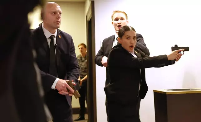 FILE - Secret service agents respond when a man, who authorities say, tried to storm the White House Correspondents' Association dinner with guns and knives, in Washington, April 25, 2026. (AP Photo/Tom Brenner, File)