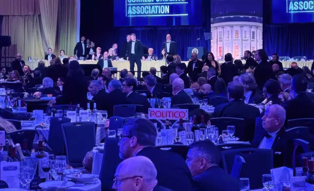 FILE - U.S. Secret Service agents respond near President Donald Trump and first lady Melania Trump during the White House Correspondents Dinner, Saturday, April 25, 2026, in Washington. (AP Photo/Alex Brandon, File)
