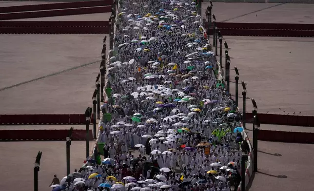 Muslim pilgrims walk on their way to cast pebbles at pillars in the symbolic stoning of the devil, the last rite of the annual Hajj, in Mina near the holy city of Mecca, Saudi Arabia, Wednesday, May 27, 2026. (AP Photo/Altaf Qadri)