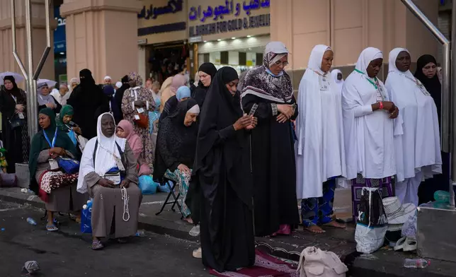 Muslim pilgrims pray afternoon prayers on a street outside the Grand Mosque during the annual Hajj pilgrimage, in the Muslim holy city of Mecca, Saudi Arabia, Friday, May 22, 2026. (AP Photo/Altaf Qadri)