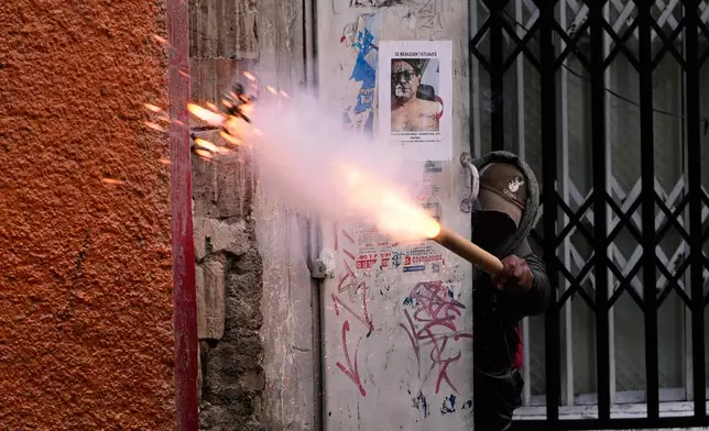 A demonstrator launches a firecracker at police during an anti-government protest in La Paz, Bolivia, Friday, May 22, 2026. (AP Photo/Juan Karita)