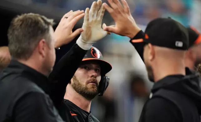 Baltimore Orioles outfielder Taylor Ward, center, celebrates after scoring on a double by Adley Rutschman, during the fifth inning of a baseball game against the Miami Marlins, Wednesday, May 6, 2026, in Miami. (AP Photo/Rebecca Blackwell)