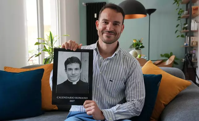 Giovanni Galizia poses with the 'Calendario Romano' calendar that has for two decades been a bestseller in Rome’s souvenir shops, at his home in Verona, Italy, Wednesday, May 20, 2026. (AP Photo/Luca Bruno)
