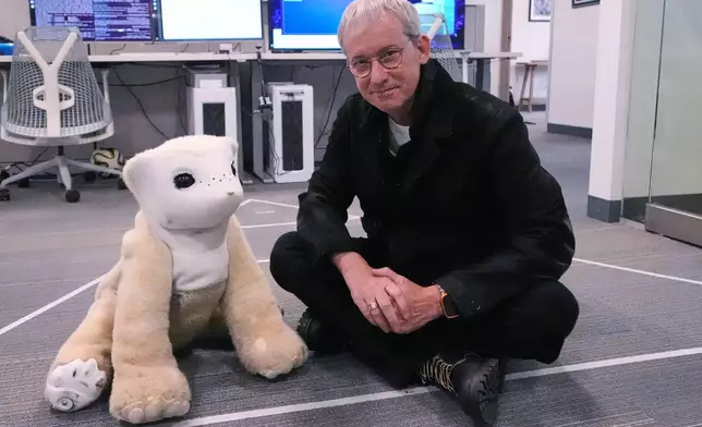 Colin Angle, co-founder and former CEO of Roomba vacuum maker, poses with Familiar, a prototype AI pet robot, at his Massachusetts-based startup Familiar Machines &amp; Magic, Wednesday, April 29, 2026, in Woburn, Mass. (AP Photo/Charles Krupa)