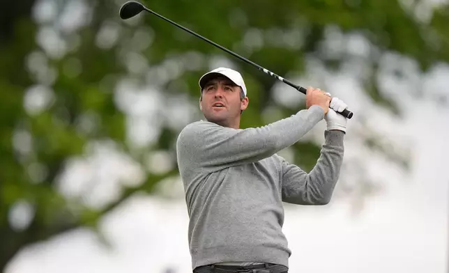 Fans watch Scottie Scheffler hits on the eighth green during the first round of the PGA Championship golf tournament at Aronimink Golf Club, Thursday, May 14, 2026, in Newtown Square, PA. (AP Photo/Frank Franklin II)