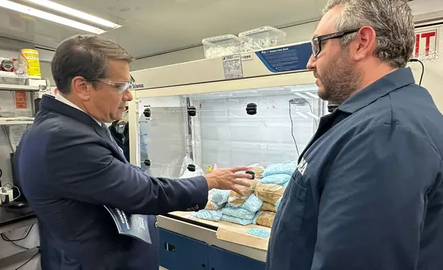 Acting Attorney General Todd Blanche talks to a technician in a Drug Enforcement Administration (DEA) mobile lab who is running tests on seized drugs in Phoenix, Wednesday, May 6, 2026. (AP Photo/Rebecca Santana)